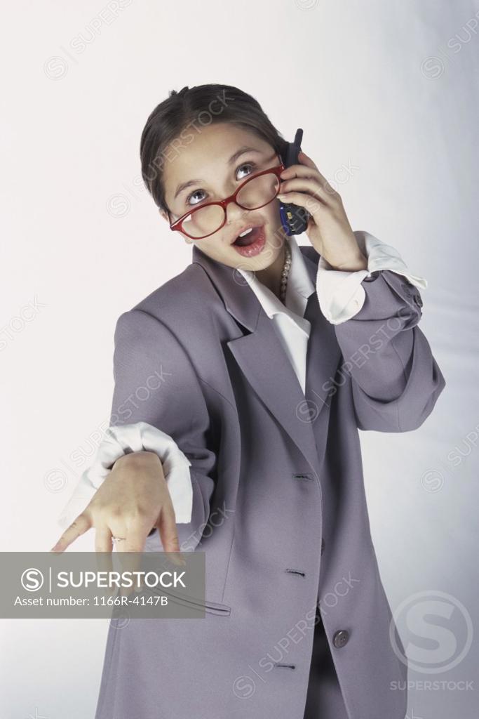 Stock Photo: 1166R-4147B Portrait of a young girl dressed as a businesswoman talking on a mobile phone