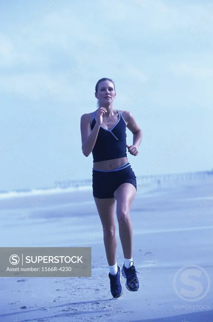 Portrait of a young woman running on the beach