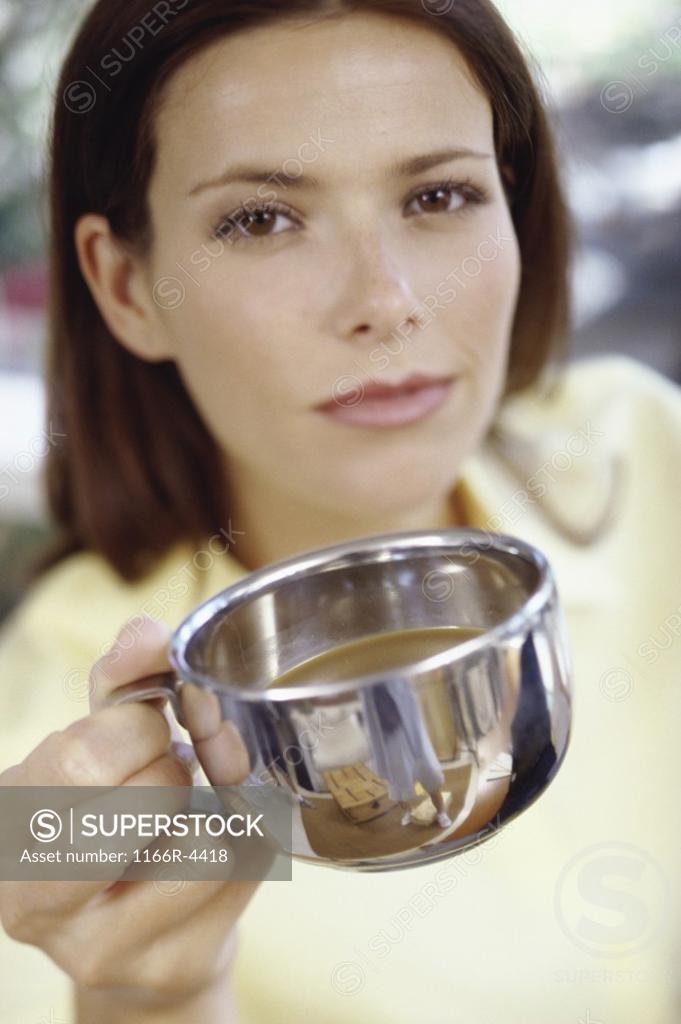 Stock Photo: 1166R-4418 Portrait of a young woman holding out a teacup