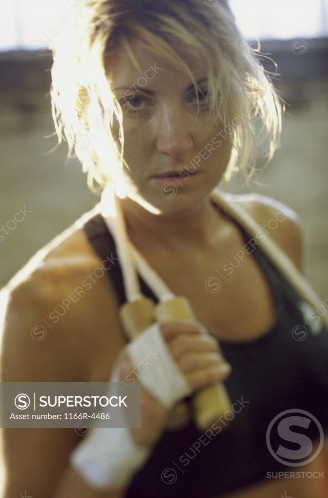 Stock Photo: 1166R-4486 Portrait of a young woman holding a jump rope around her neck