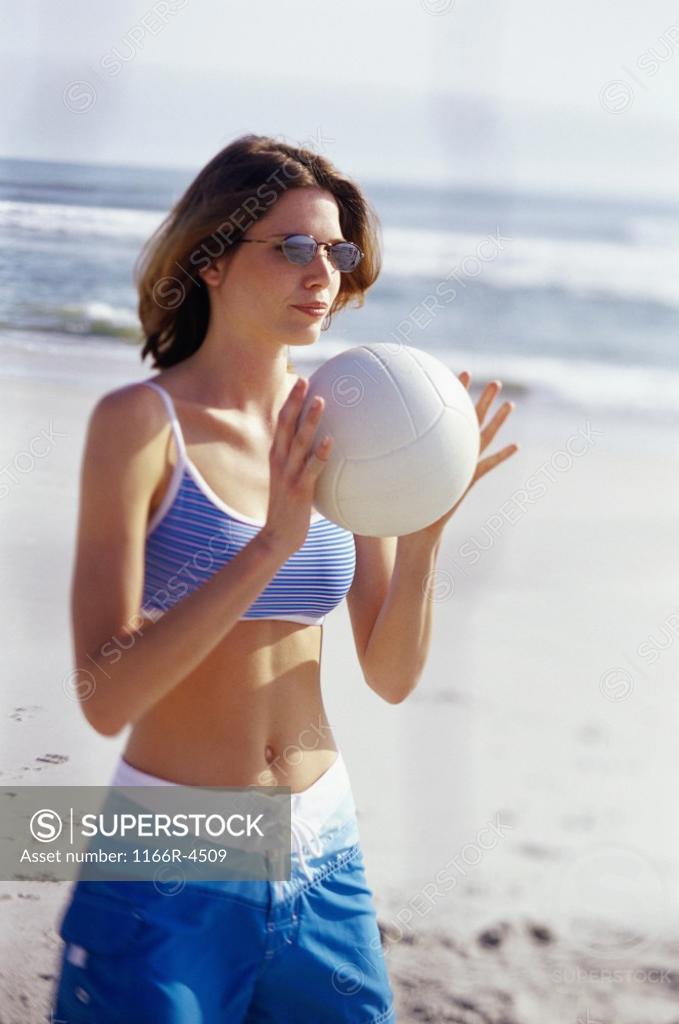 Stock Photo: 1166R-4509 Young woman holding a volleyball