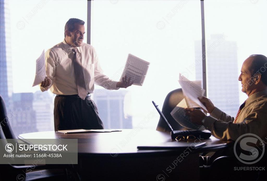 Stock Photo: 1166R-4538A Two businessmen holding documents in an office
