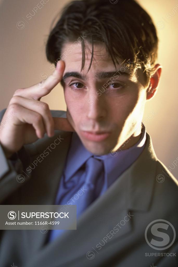 Stock Photo: 1166R-4599 Portrait of a businessman with a finger against his head