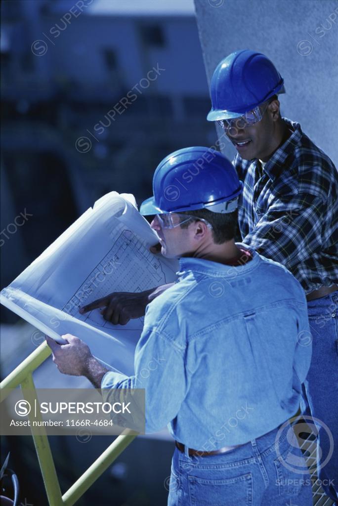 Stock Photo: 1166R-4684 High angle view of two foremen working on blueprints