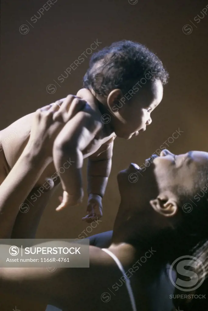 Side profile of a baby boy in his mother's arms
