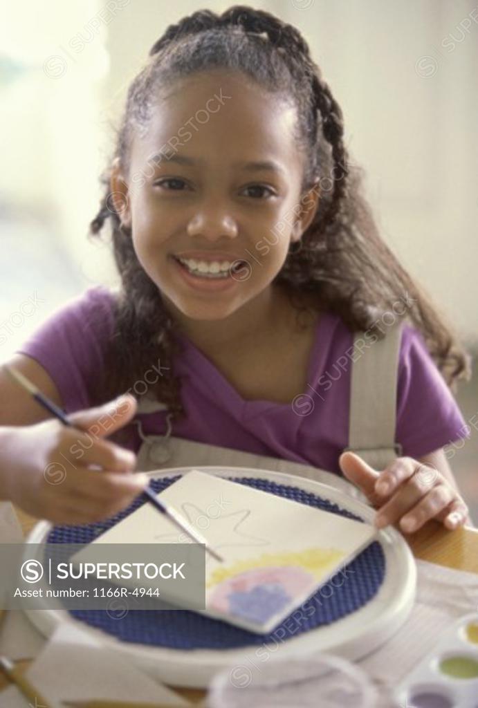 Stock Photo: 1166R-4944 Portrait of a girl painting on a tile