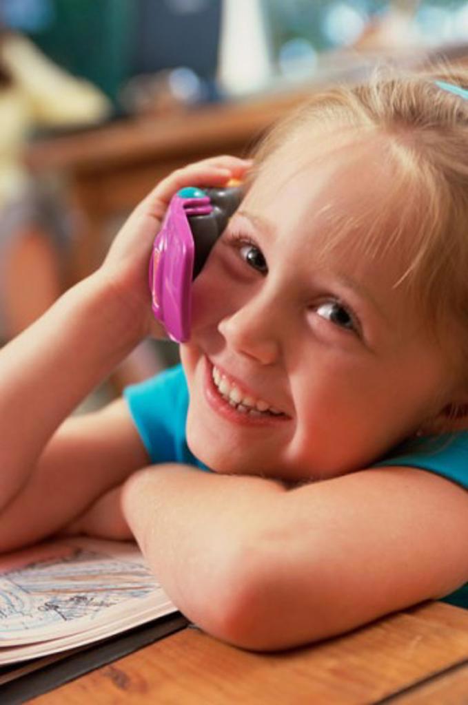 Portrait of a girl talking on a toy phone