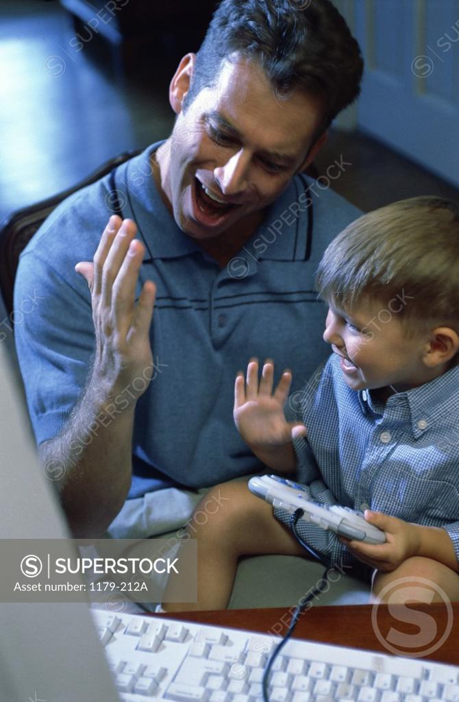 Stock Photo: 1179-212A Father and his son playing video games