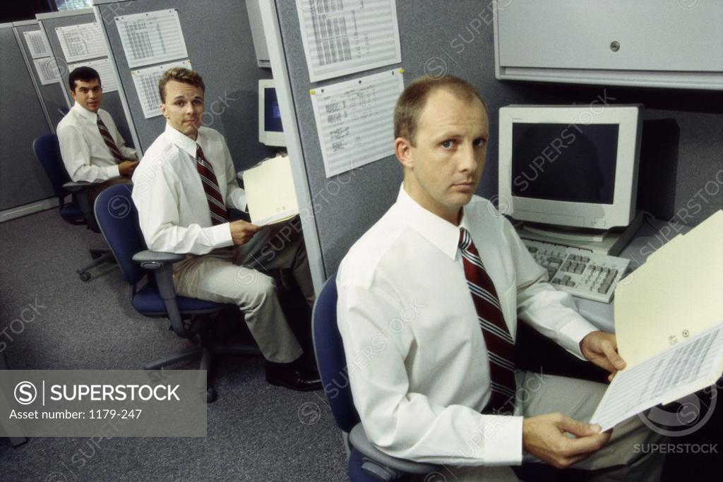 Stock Photo: 1179-247 Portrait of three businessmen working in office cubicles