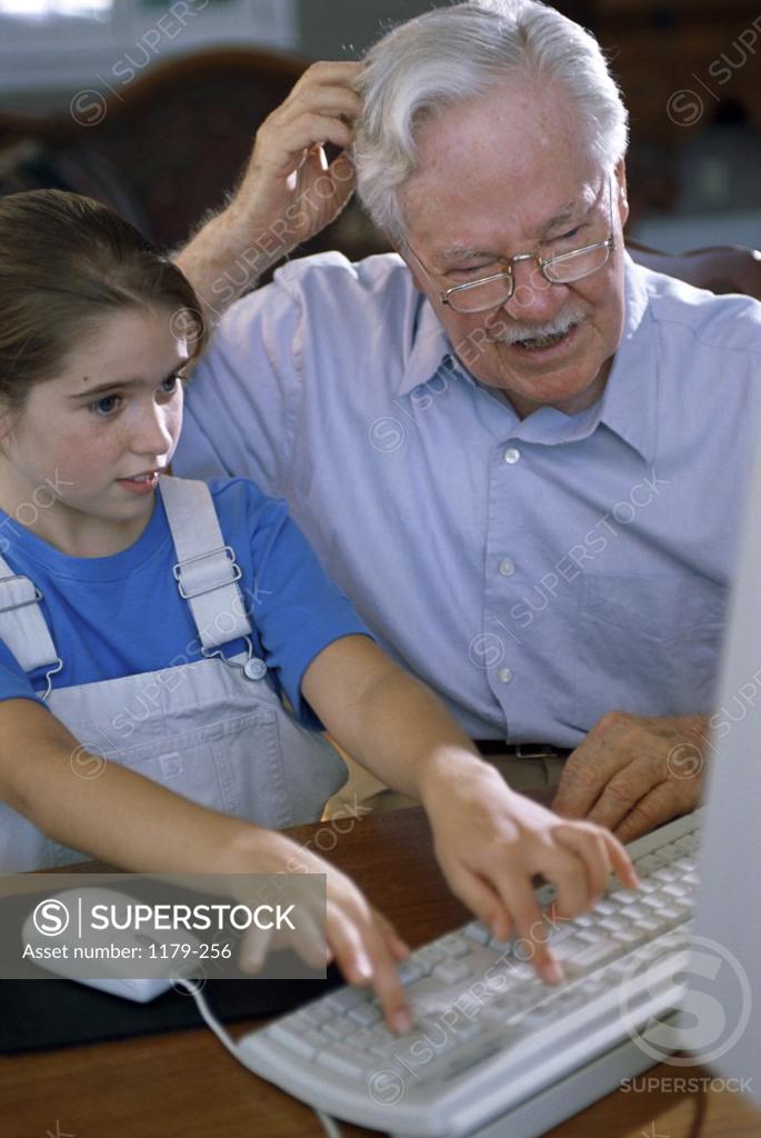 Stock Photo: 1179-256 Grandfather and his granddaughter using a computer