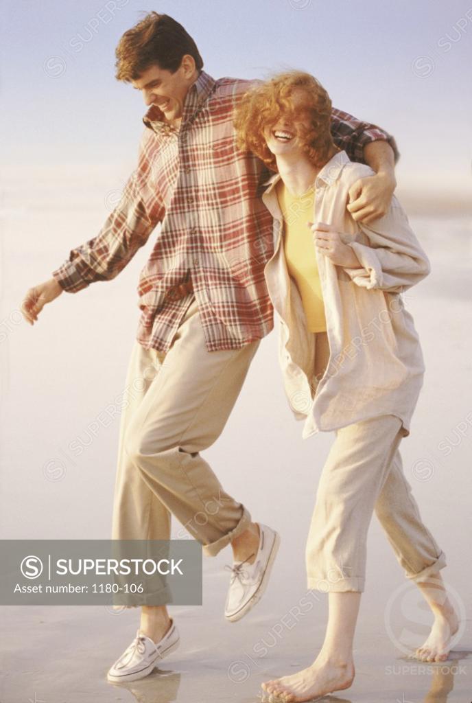 Stock Photo: 1180-106 Young couple walking together on the beach