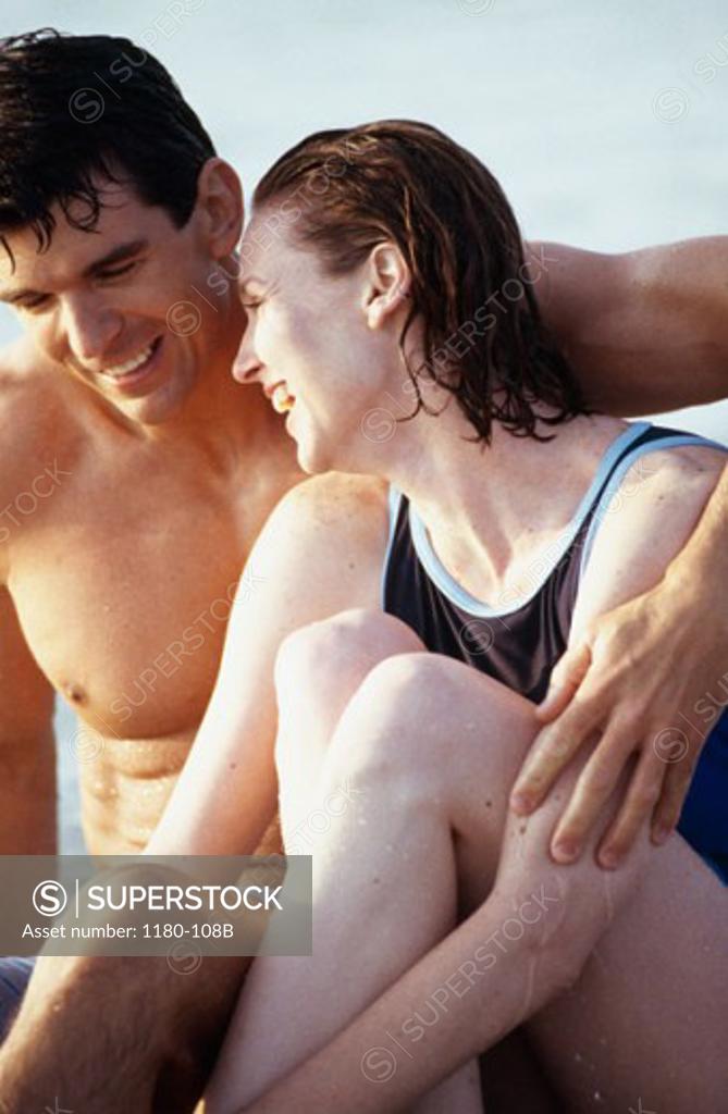 Stock Photo: 1180-108B Mid adult man with his arm around a mid adult woman and smiling