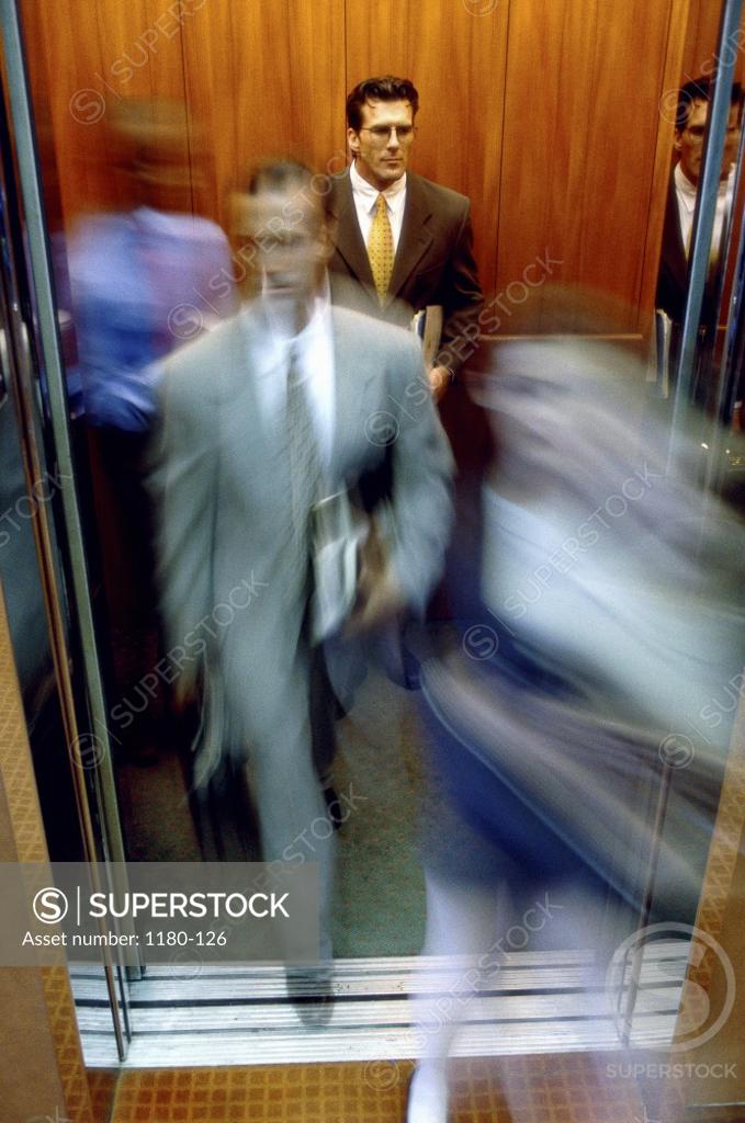 Stock Photo: 1180-126 Businessman and a businesswoman exiting an elevator