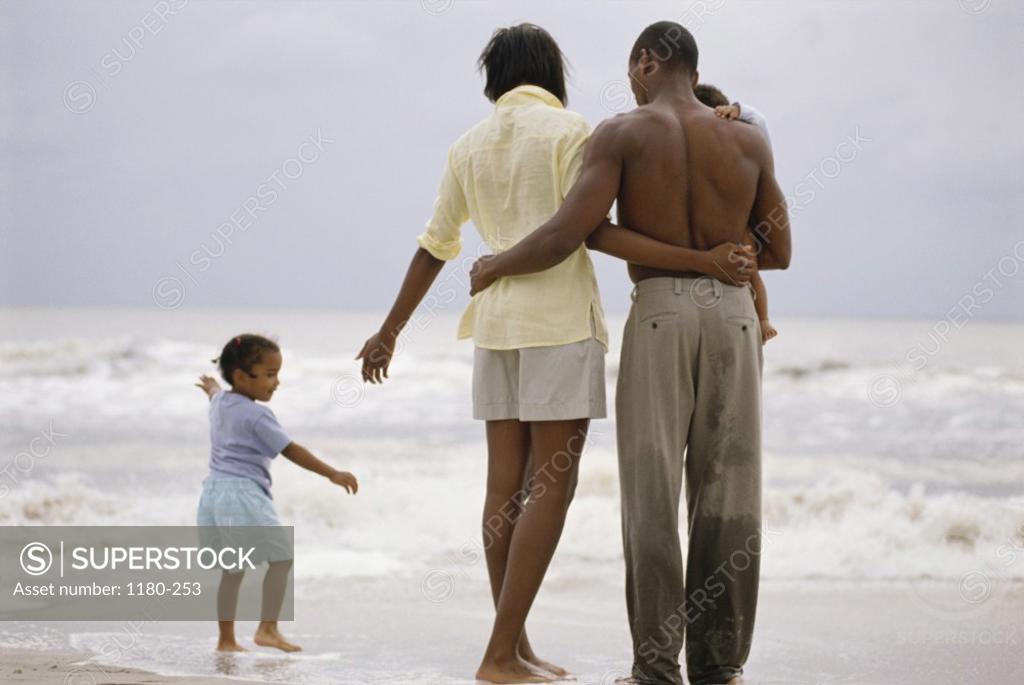 Stock Photo: 1180-253 Young couple on the beach with their two daughters