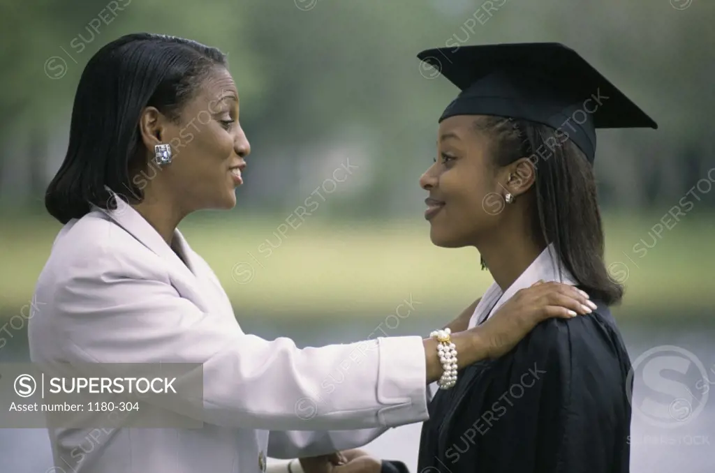 Side profile of a young female graduate with her mother