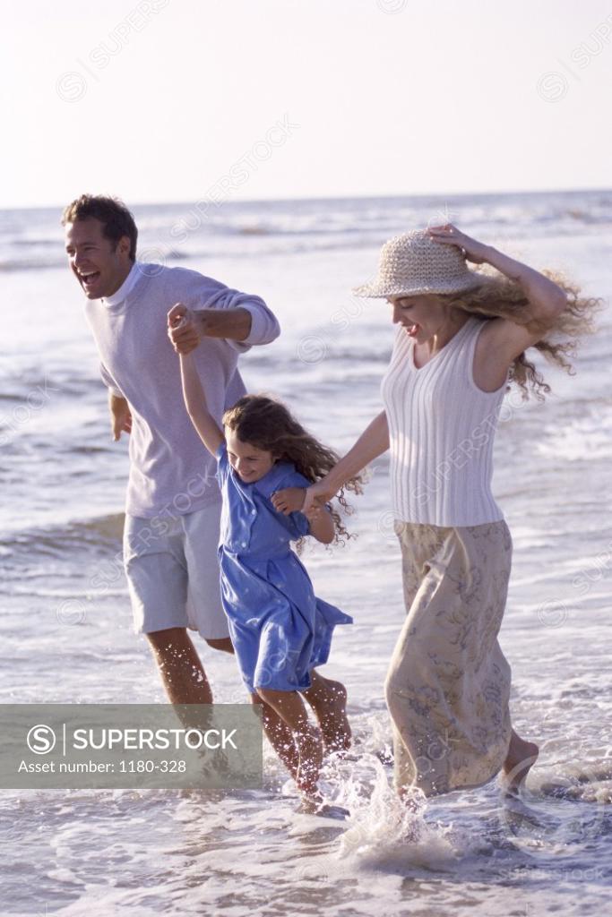 Stock Photo: 1180-328 Young couple on the beach with their daughter
