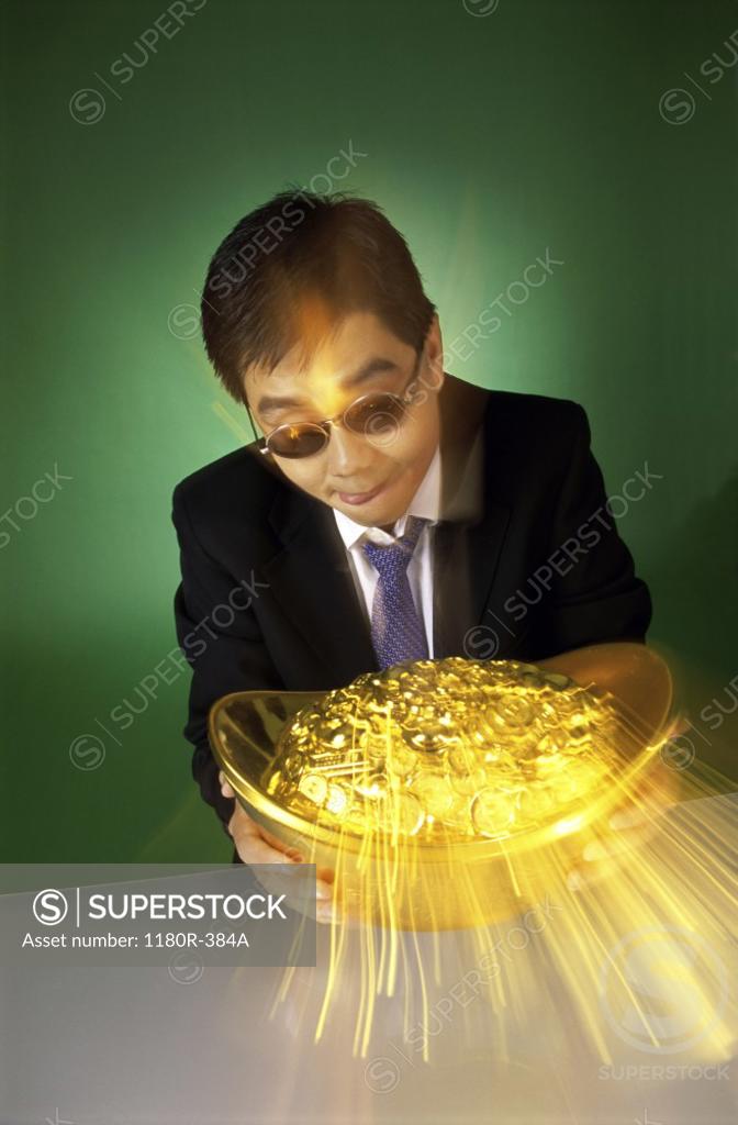 Stock Photo: 1180R-384A Businessman holding a pot of gold