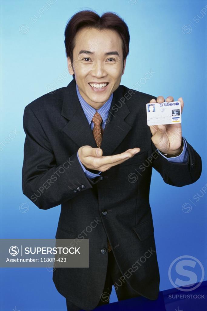 Stock Photo: 1180R-423 Portrait of a young man holding a credit card
