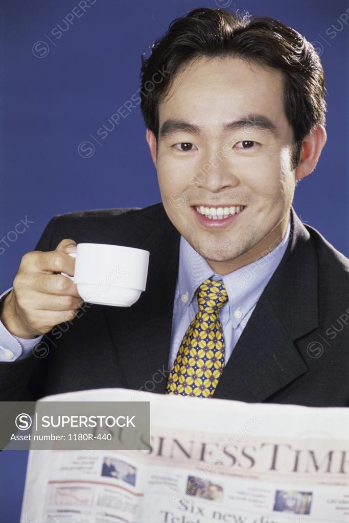 Stock Photo: 1180R-440 Portrait of a businessman smiling and holding a coffee cup