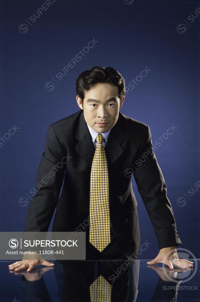 Stock Photo: 1180R-441 Portrait of a businessman leaning against a desk