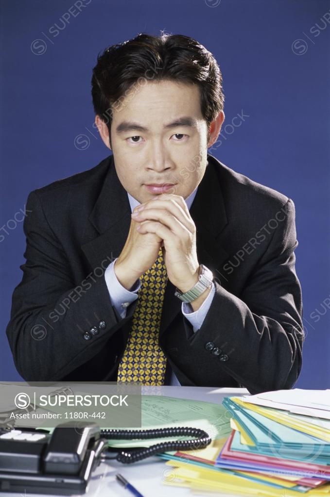 Stock Photo: 1180R-442 Portrait of a businessman seated behind an office desk