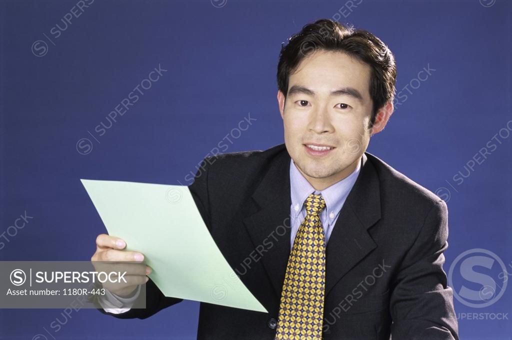 Stock Photo: 1180R-443 Portrait of a businessman holding a sheet of paper