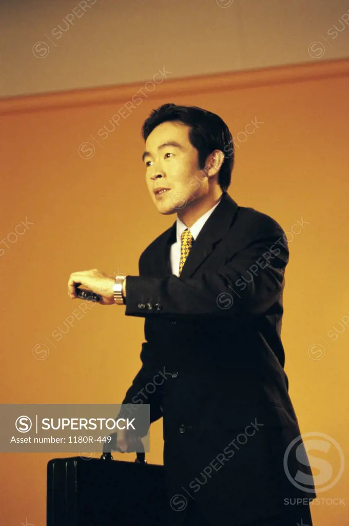 Side profile of a businessman looking at his wristwatch