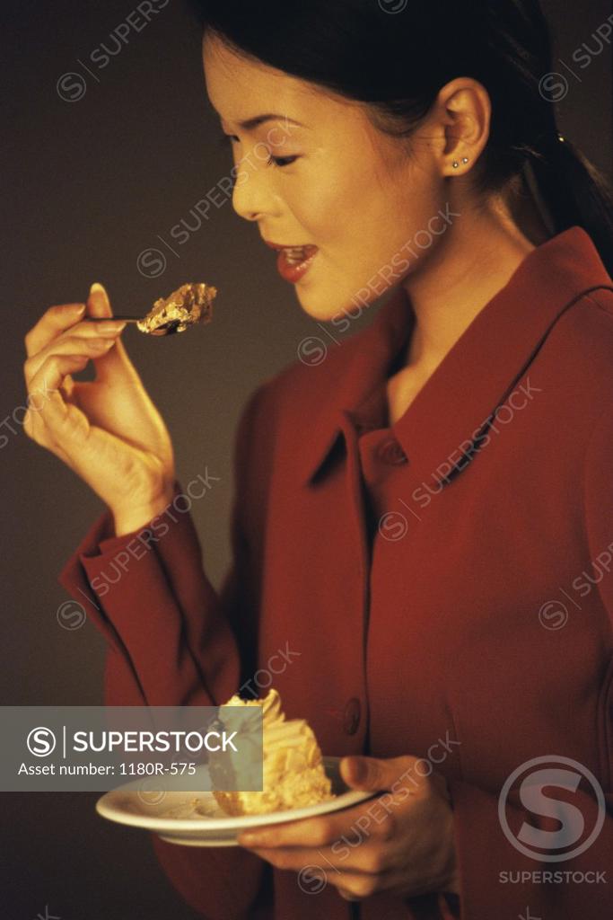 Stock Photo: 1180R-575 Side profile of a young woman eating a slice of cake
