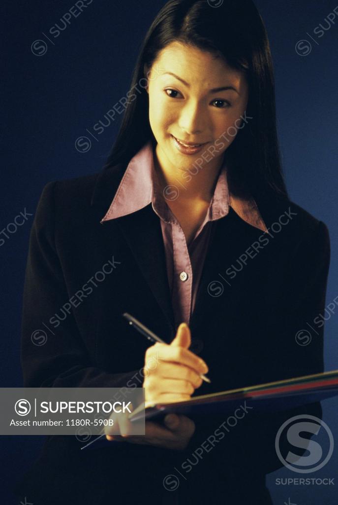 Stock Photo: 1180R-590B Portrait of a businesswoman writing on paper