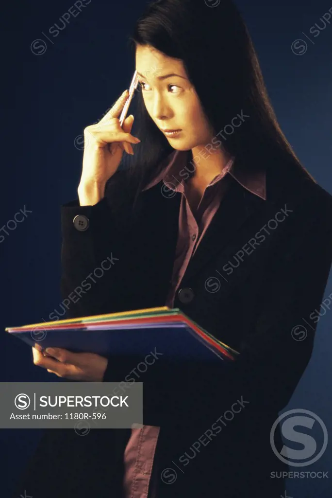 Portrait of a businesswoman holding a pen against her head