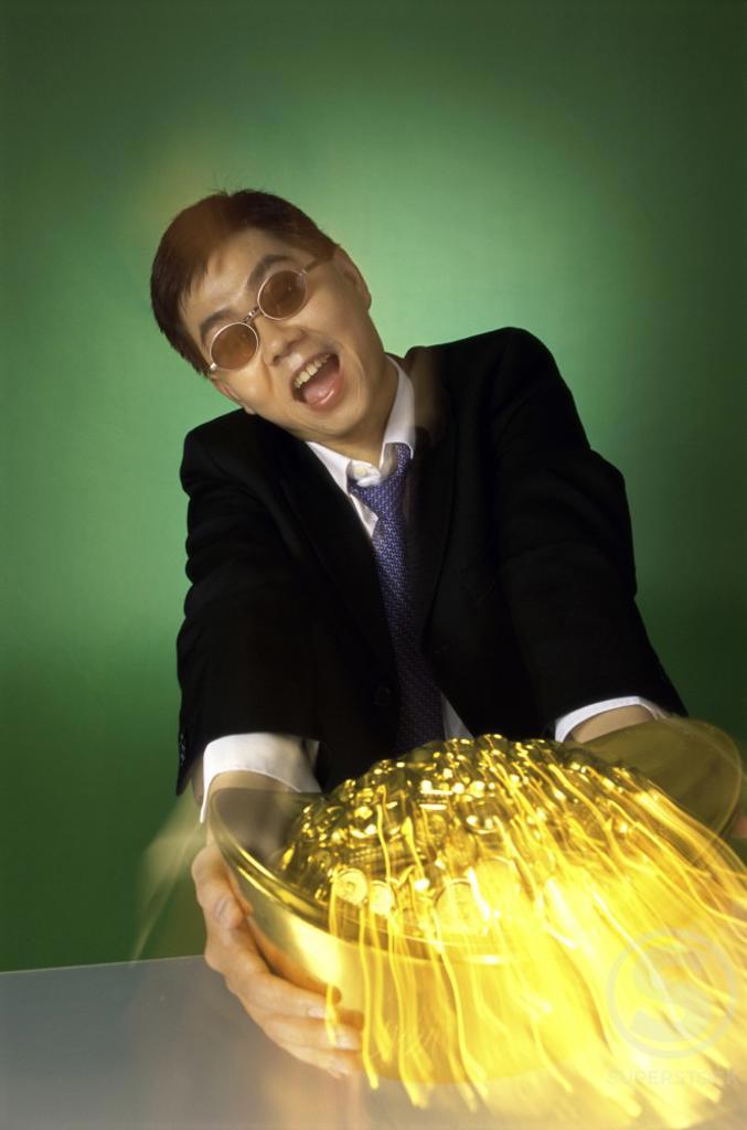 Portrait of a businessman holding a pot of gold