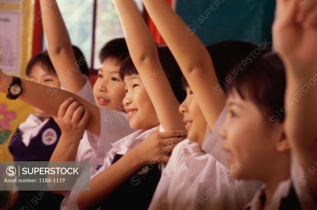 Stock Photo: 1188-1119 Group of children raising their hands in a row and smiling