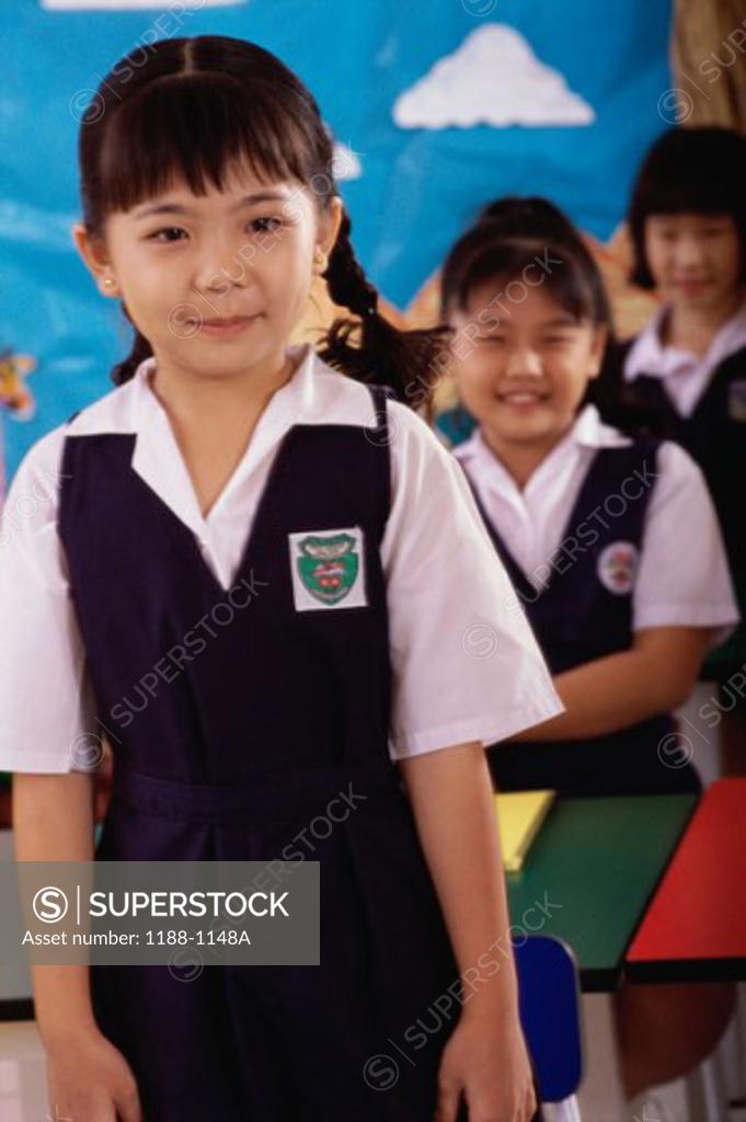 Stock Photo: 1188-1148A Three girls standing in a classroom