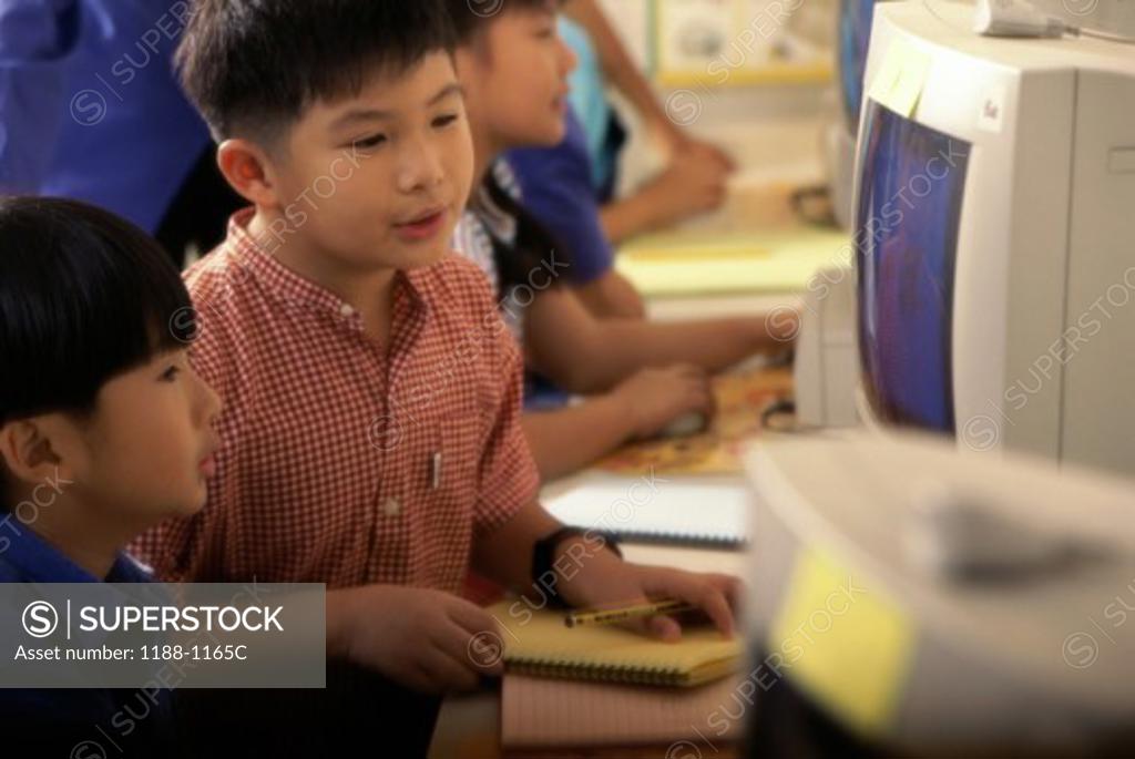 Stock Photo: 1188-1165C Children sitting in a row in front of computers