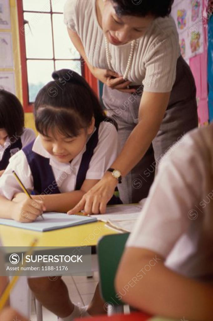 Stock Photo: 1188-1176 Teacher helping her students in a classroom