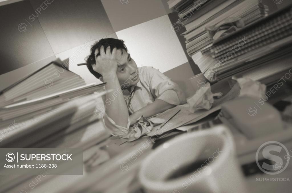Stock Photo: 1188-238 Businessman sitting at a desk with a pile of paperwork