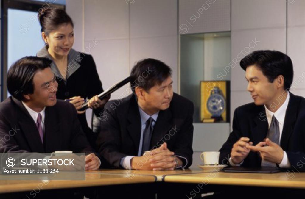 Stock Photo: 1188-254 Businesswoman with three businessmen talking in an office