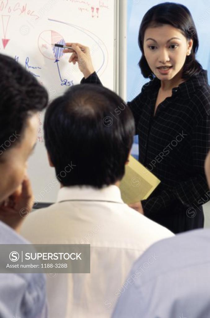 Stock Photo: 1188-328B Businesswoman pointing to a pie chart on a whiteboard