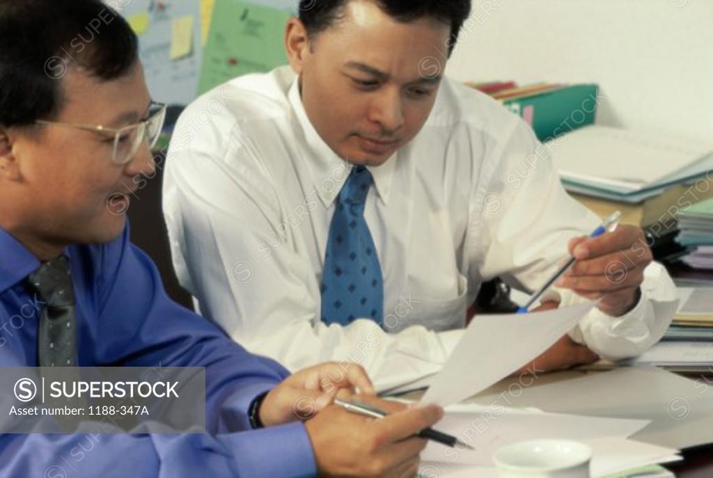 Stock Photo: 1188-347A Two businessmen talking in an office