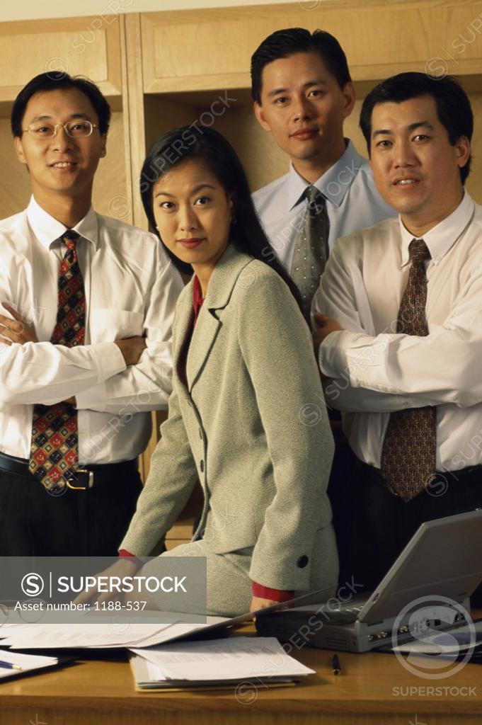 Stock Photo: 1188-537 Portrait of three businessmen and a businesswoman smiling in an office