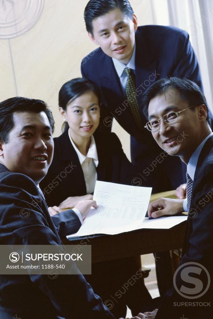 Stock Photo: 1188-540 Portrait of three businessmen and a businesswoman smiling in an office