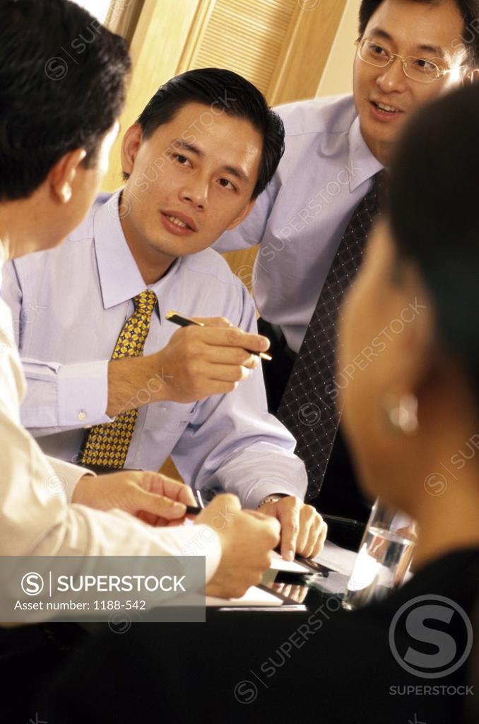 Stock Photo: 1188-542 Businesswoman with three businessmen talking in an office