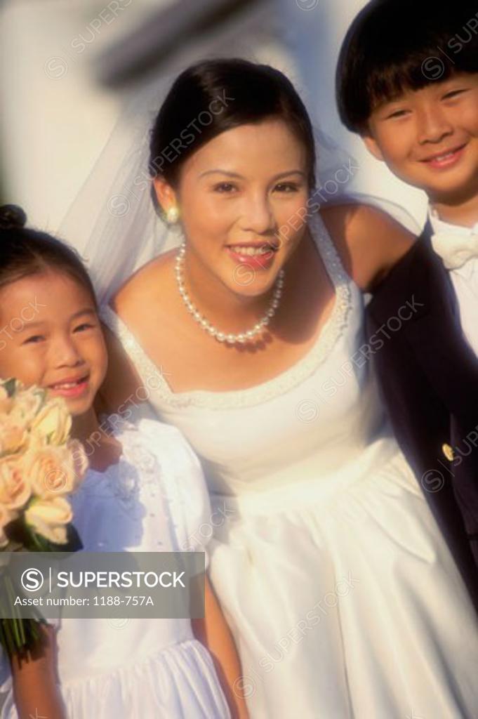 Stock Photo: 1188-757A Portrait of a bride standing with a flower girl and a ring bearer