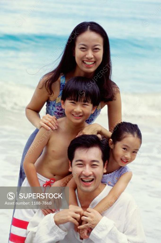 Stock Photo: 1188-786B Mid adult couple with their son and daughter smiling on the beach