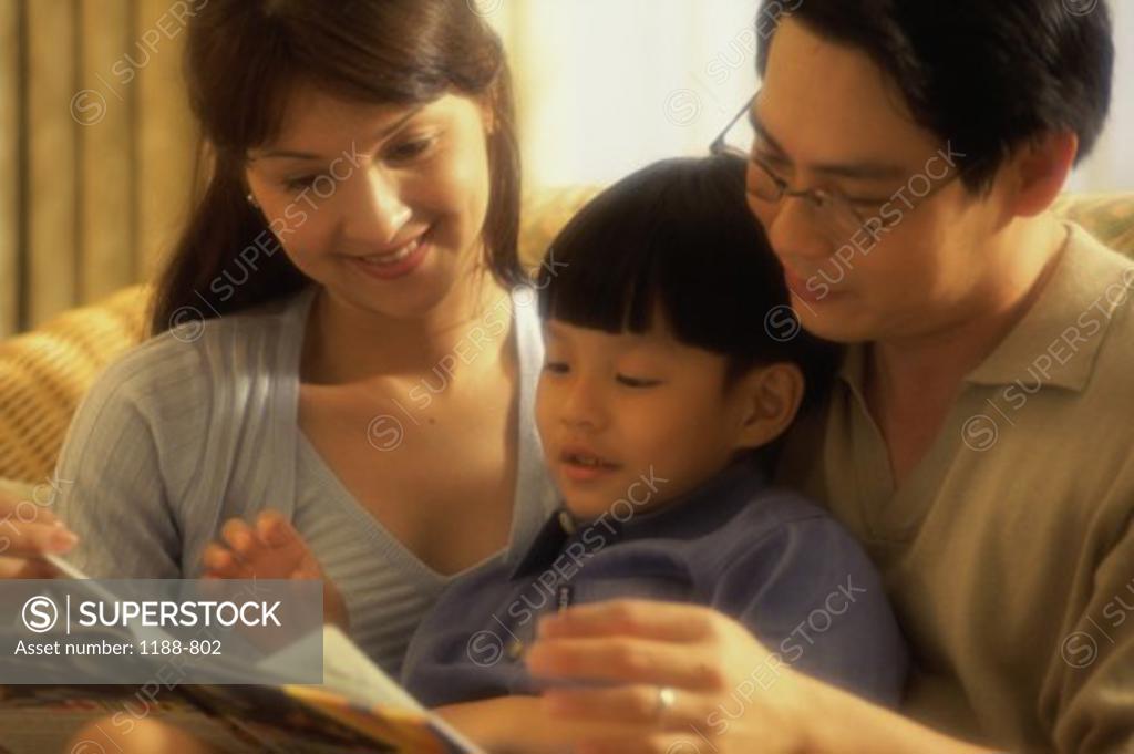 Stock Photo: 1188-802 Parents with their son reading a book