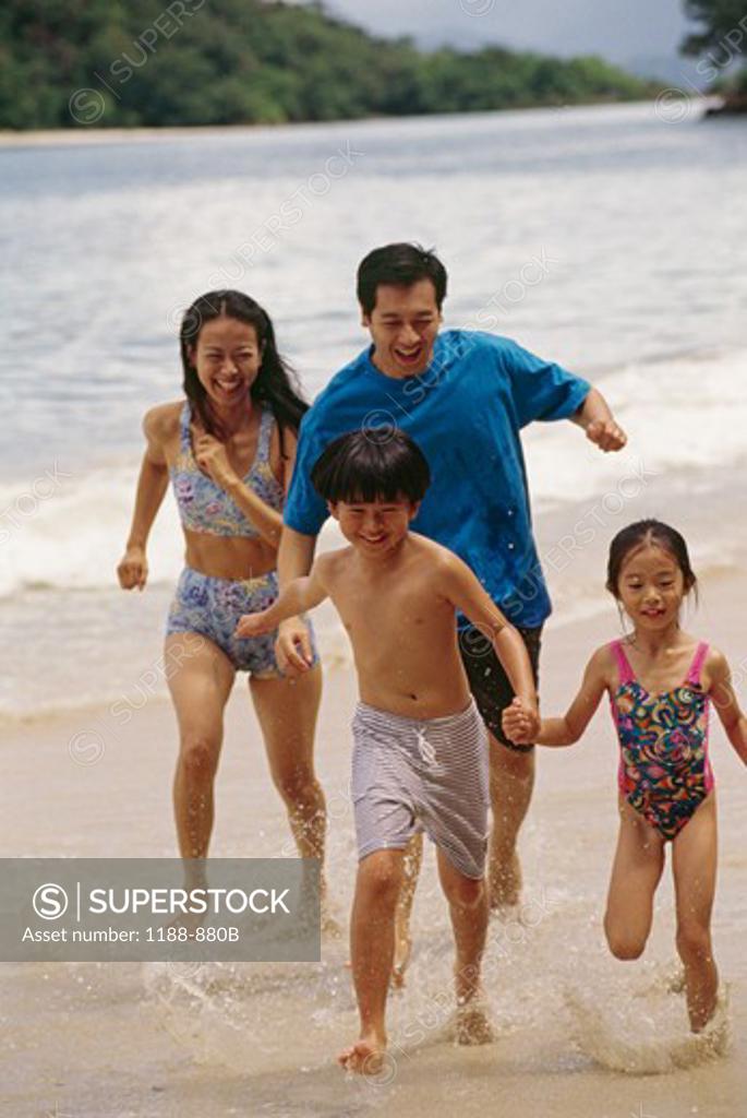 Stock Photo: 1188-880B Family with two children running on beach