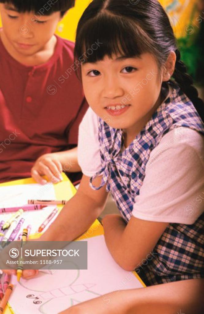 Stock Photo: 1188-957 Portrait of a girl coloring in a crayon book