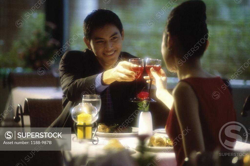 Stock Photo: 1188-987B Young couple toasting in a restaurant