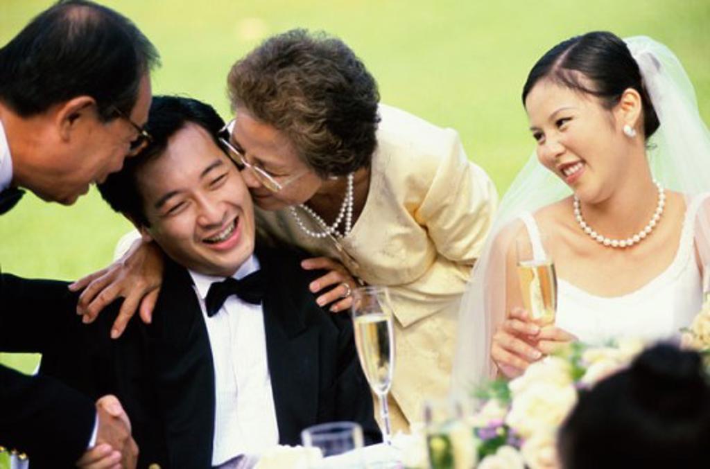 Close-up of a mother kissing the groom