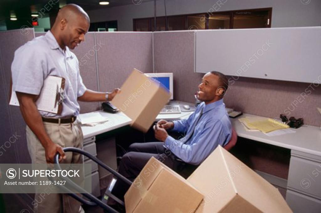 Stock Photo: 1189-1427 Delivery man giving a package to a businessman